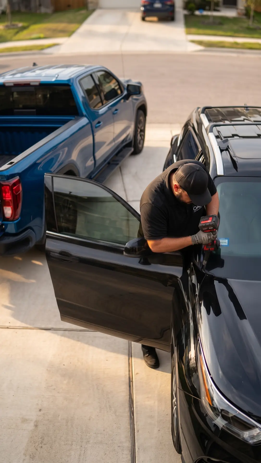Oscar Auto Glass technician replacing a door window in a suburban Austin driveway